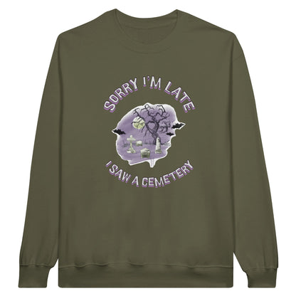 Gildan 18000 Crewneck Sweatshirt with the words Sorry I'm Late I saw a cemetery around a graphic of a cemetery.  Colors of the graphic are purple and grey. Sweatshirt is military green.