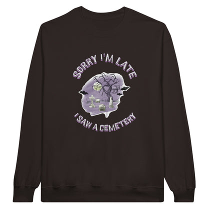 Gildan 18000 Crewneck Sweatshirt with the words Sorry I'm Late I saw a cemetery around a graphic of a cemetery.  Colors of the graphic are purple and grey. Sweatshirt is dark brown