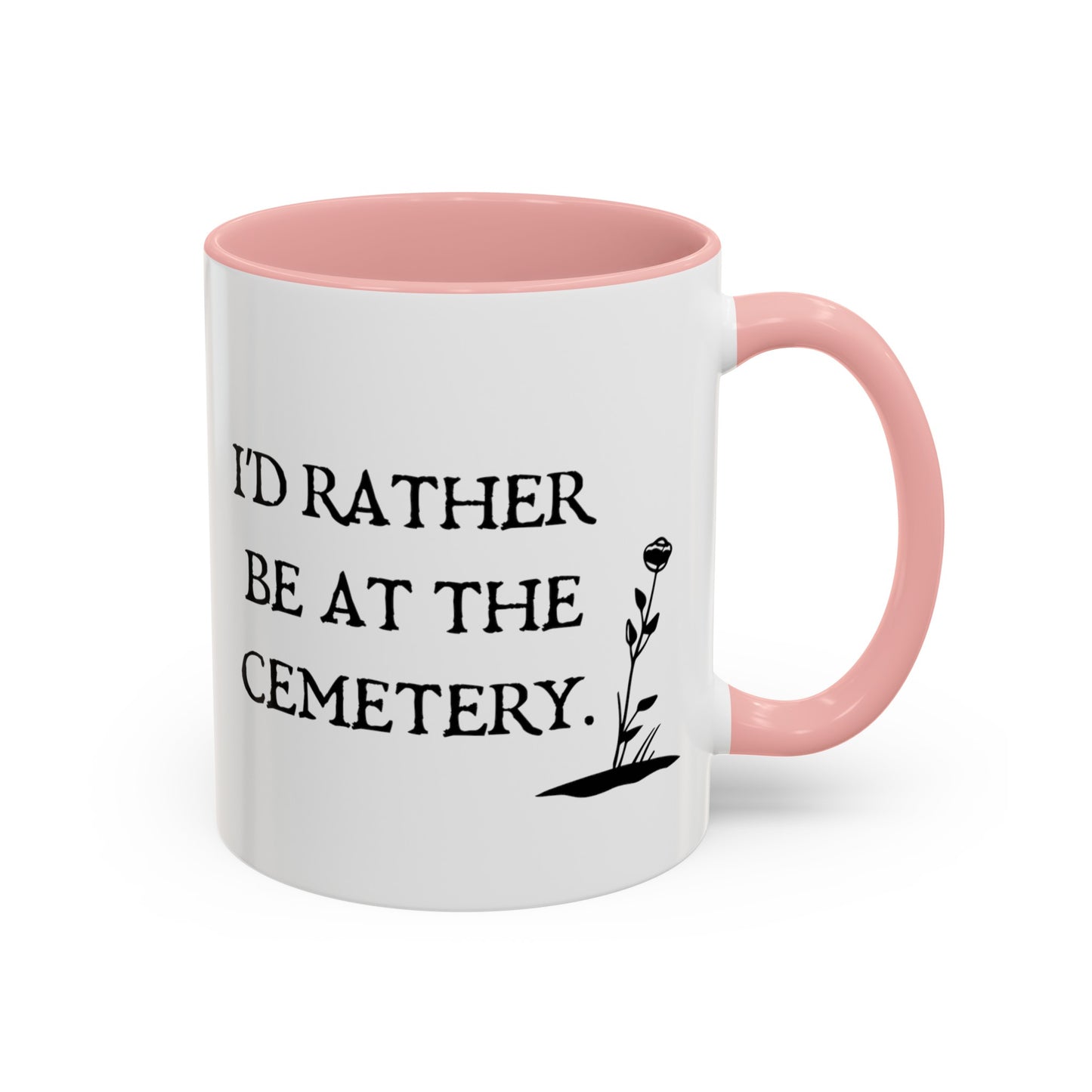 15 oz white ceramic mug with a pink handle and pink interior. One side says Id rather be at the cemetery the other side has a tombstone with a skull on it