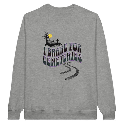 Gildan 18000 Crewneck Sweatshirt with the words I Brake For Cemeteries in black and grey with purples shading accents.. There are skid marks under the words and a small graveyard graphic to the top left of the words. The sweatshirt is heather grey