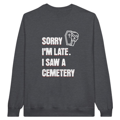 Gildan 18000 Crewneck Sweatshirt with the words Sorry I'm Late. I Saw A Cemetery in white and a small skull and coffin graphic to the top right of the text. Shirt is dark heather grey