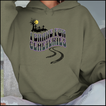 Gildan 18500 Hoodie Sweatshirt with the words I Brake For Cemeteries in black and grey with purples shading accents.. There are skid marks under the words and a small graveyard graphic to the top left of the words. The hoodie is military green.