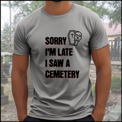 Bella Canvas 3001 T-Shirt with  the words Sorry I'm Late. I Saw A Cemetery in black and a small skull and coffin graphic to the top right of the text. Shirt is athletic grey.