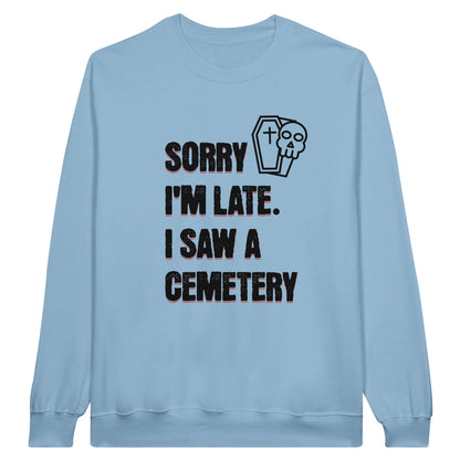 Gildan 18000 Crewneck Sweatshirt with the words Sorry I'm Late. I Saw A Cemetery in black and a small skull and coffin graphic to the top right of the text. Shirt is light blue