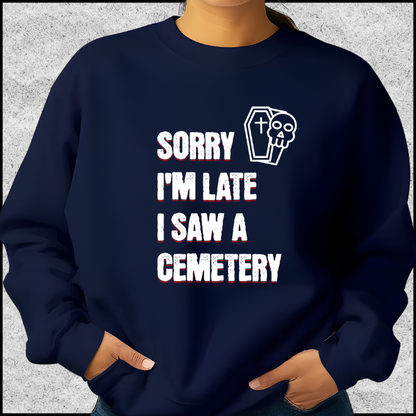 Gildan 18000 Crewneck Sweatshirt with the words Sorry I'm Late. I Saw A Cemetery in white and a small skull and coffin graphic to the top right of the text. Shirt is navy blue.