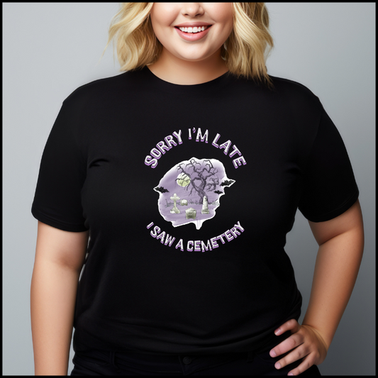 Bella Canvas 3001 T-Shirt  with the words Sorry I'm Late I saw a cemetery around a graphic of a cemetery.  Colors of the graphic are purple and grey. T-shirt is black.