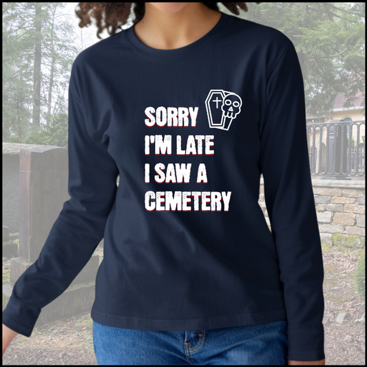 with the words Sorry I'm Late. I Saw A Cemetery in white and a small skull and coffin graphic to the top right of the text. Shirt is navy blue.