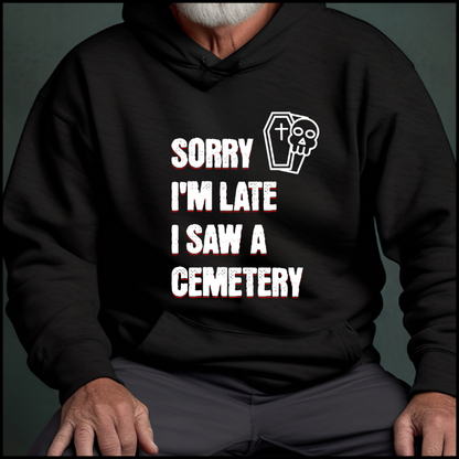 Gildan 18500 Hoodie Sweatshirt with the words Sorry I'm Late. I Saw A Cemetery in white and a small skull and coffin graphic to the top right of the text. Hoodie is black.