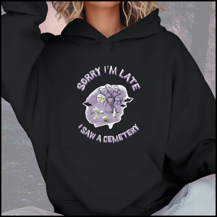 Gildan 18500 Hoodie Sweatshirt with the words Sorry Im Late I saw a cemetery around a graphic of a cemetery.  Colors of the graphic are purple and grey. Hoodie is black.