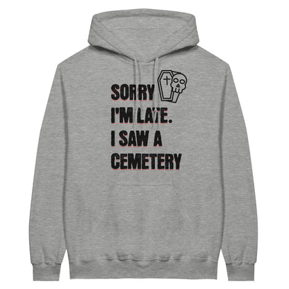 Gildan 18500 Hoodie Sweatshirt with the words Sorry I'm Late. I Saw A Cemetery in black and a small skull and coffin graphic to the top right of the text. Hoodie is ash grey